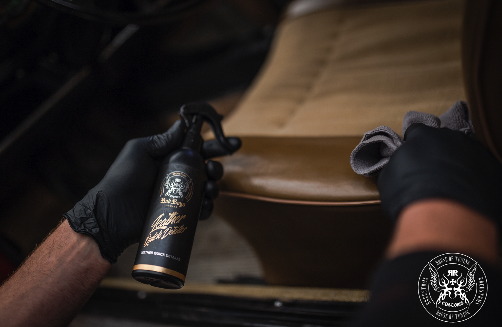 Leather Quick Detailer – Main gantée tenant le flacon près du panneau intérieur en cuir caramel | Soin Cuir | miio Store