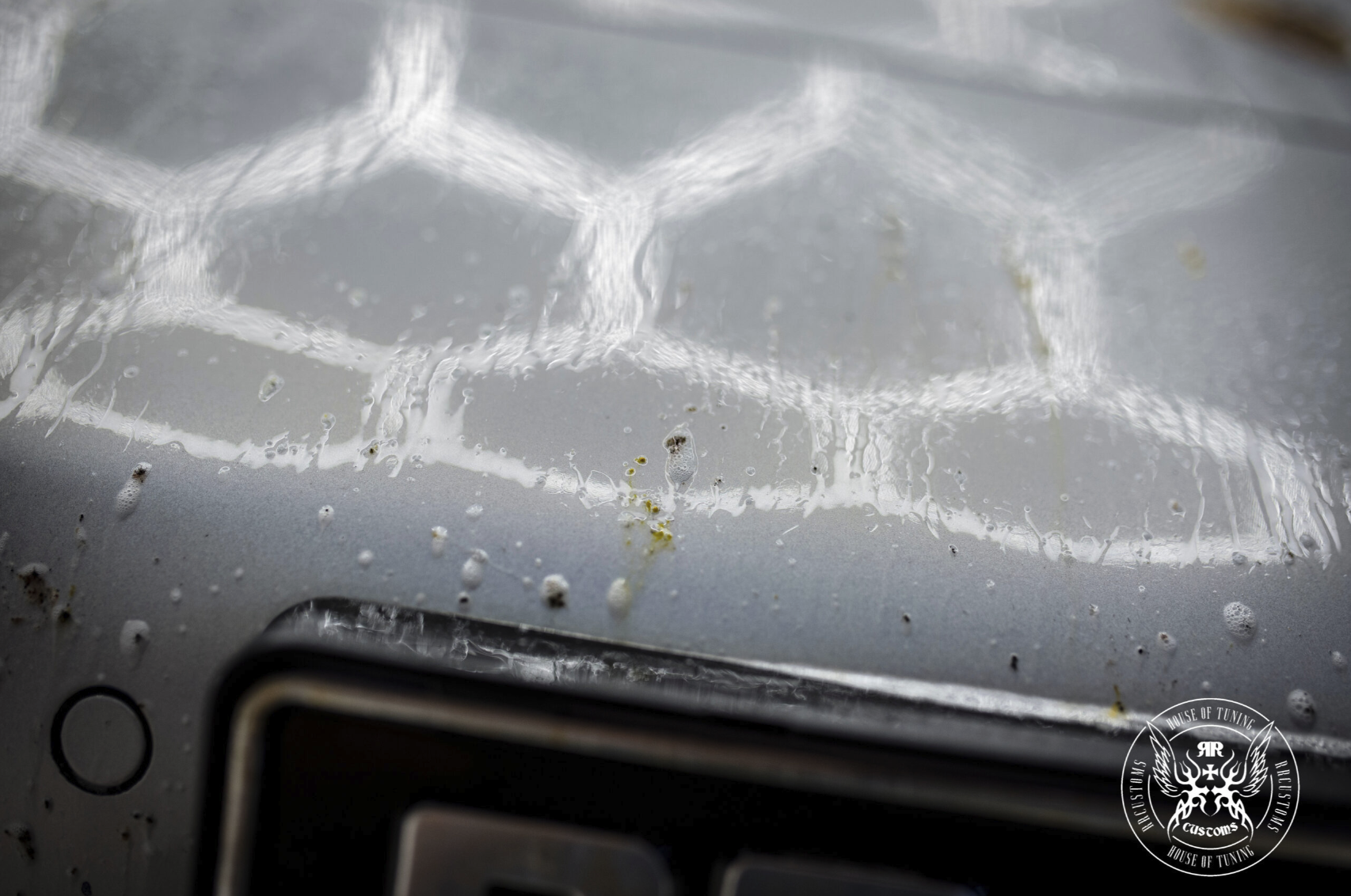 Bug Remover 1L – Panneau peinture sombre avec reflet lumière hexagonale en studio, montrant contamination à traiter | Detailing Auto | miio Store